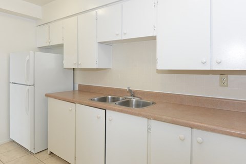 a kitchen with white cabinets and a sink and a refrigerator